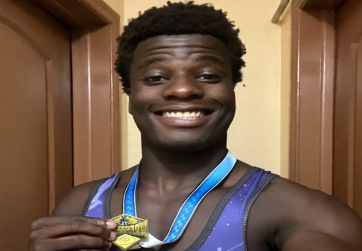 TAKING THE WIN: Senior Jeremiah Louis, smiling at the camera after coming in first place following his off-season wrestling tournament.